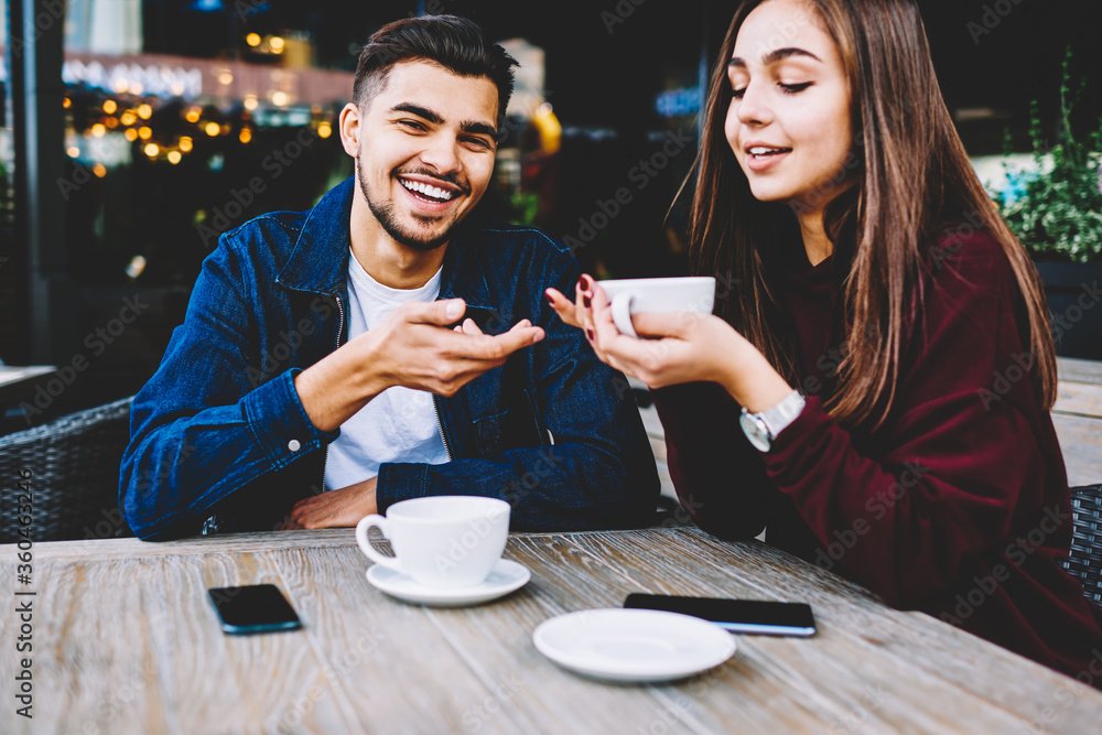 Two people laughing over coffee during a casual date, showcasing the relaxed vibe of dating.